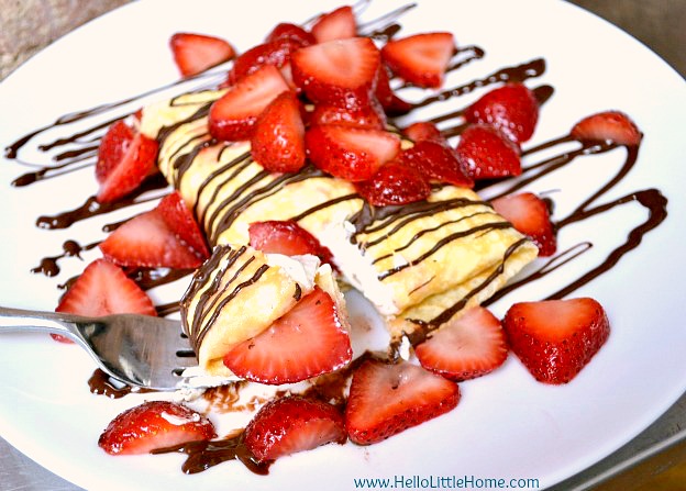 Strawberry and Cream Cheese Crepes on a plate with Chocolate Sauce.