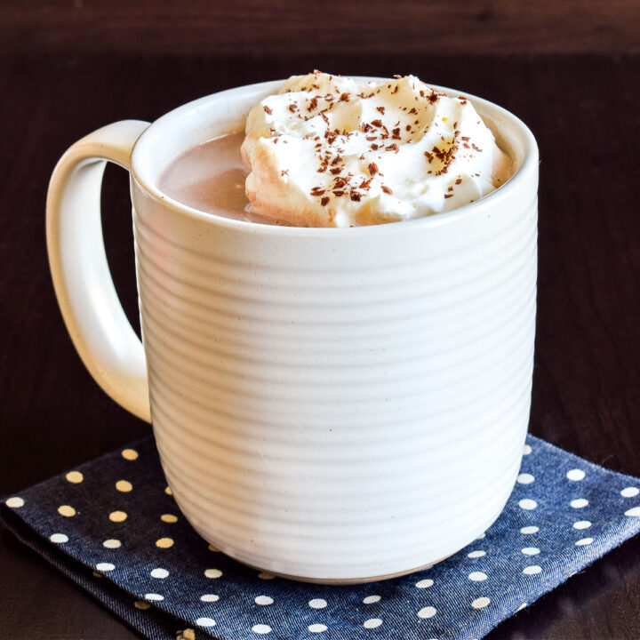 A mug of hot chocolate on a polka dot napkin.