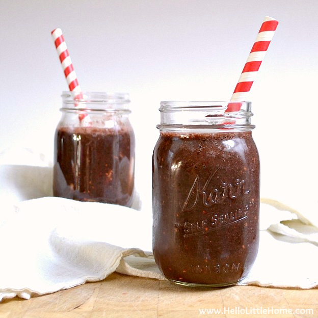Two Berry Green Smoothies in Mason Jars with Straws.
