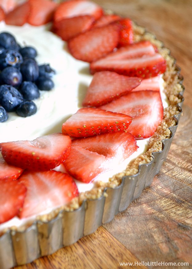 No Bake Red, White, and Blue Cheesecake Tart ... perfect for every summer party! This easy no bake cheesecake recipe is lightly flavored with lemon, made with a simple graham cracker crust, and topped with fresh strawberries and blueberries. An easy patriotic dessert recipe that's perfect for any summer holiday, like 4th of July and Memorial Day! | Hello Little Home