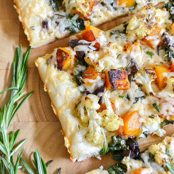 Closeup of the finished Fall Pizza next to a sprig of rosemary.