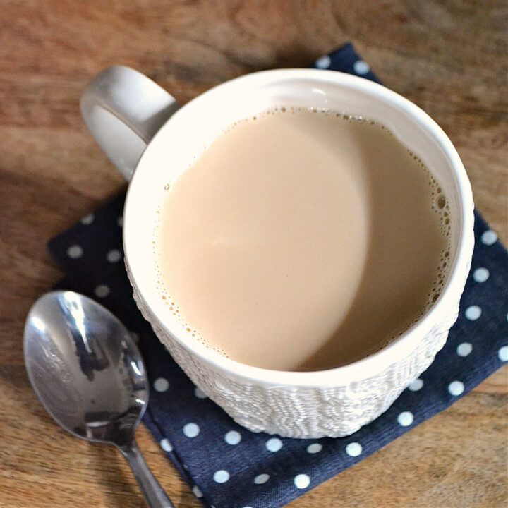 A overhead image of a cup of cinnamon milk tea on a polka dot napkin.