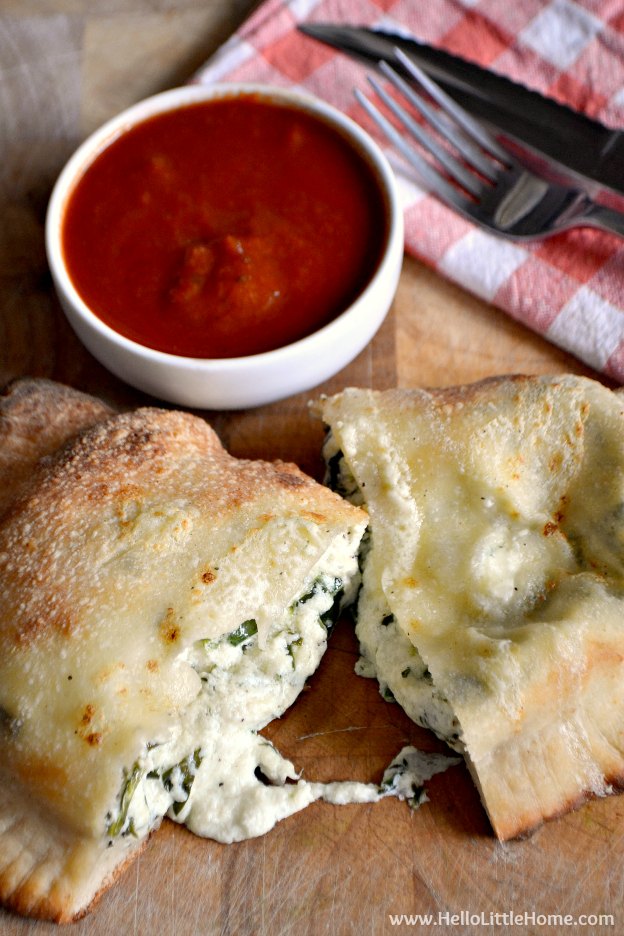 A calzone cut in half and served with marinara sauce.