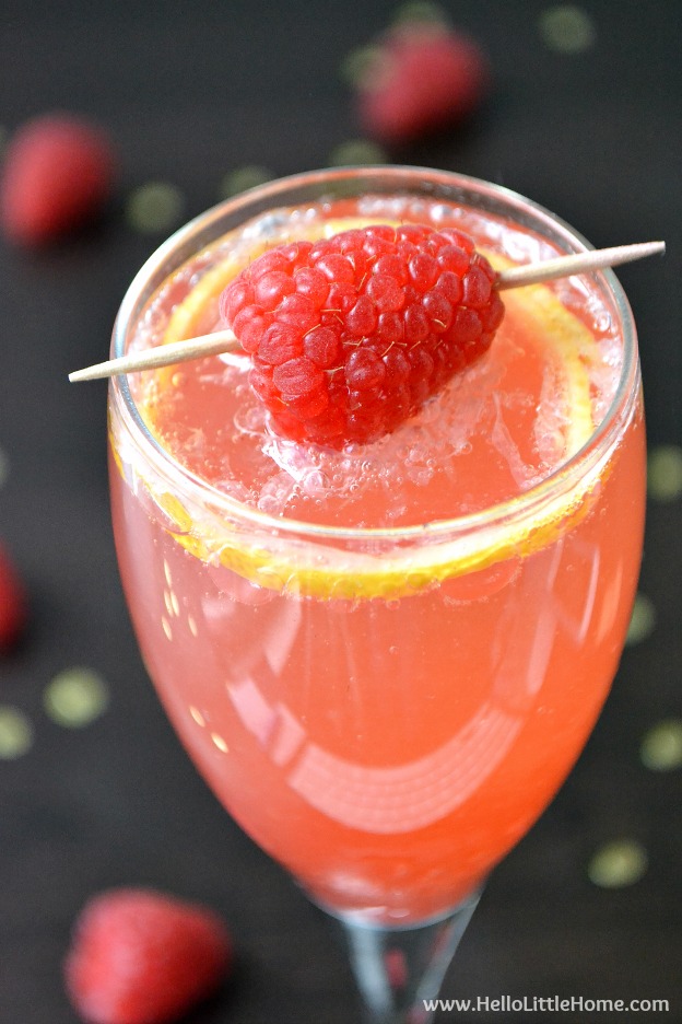 Closeup of a Raspberry French 75 garnished with a fresh raspberry.