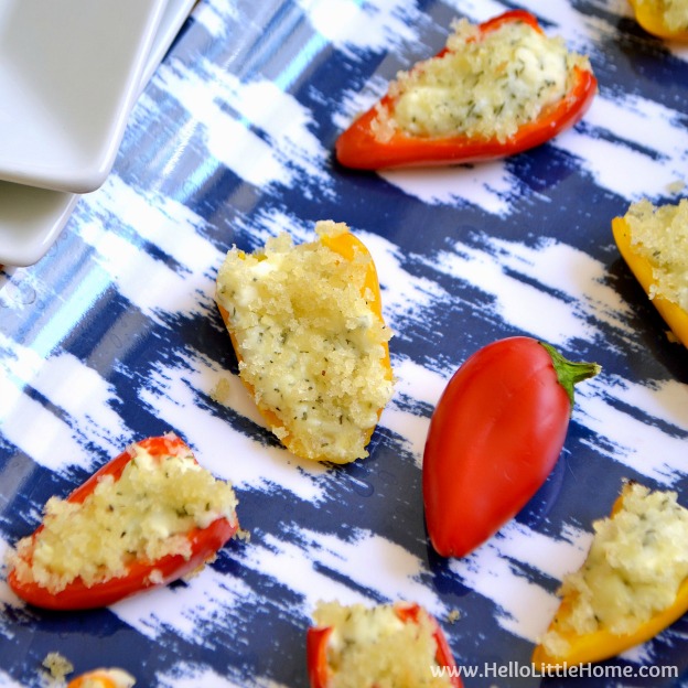 Feta stuffed mini bell peppers on a blue tray.