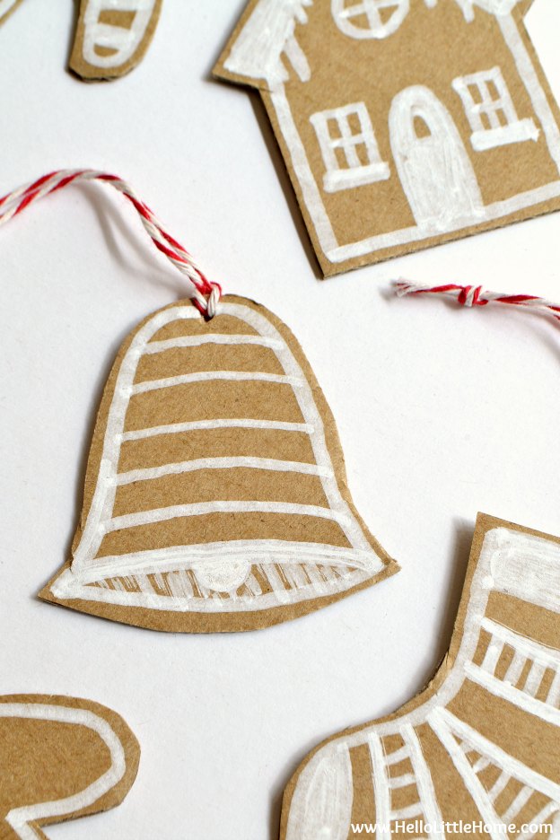 DIY Cardboard Gingerbread Ornaments ... make your own Christmas ornaments with this fun, easy, and CHEAP tutorial! These DIY Christmas ornaments are a great holiday craft for kids and for adults that’s made from paper. Use these simple DIY Christmas ornaments for your tree, for gift decorating, or give them as a holiday present! | Hello Little Home
