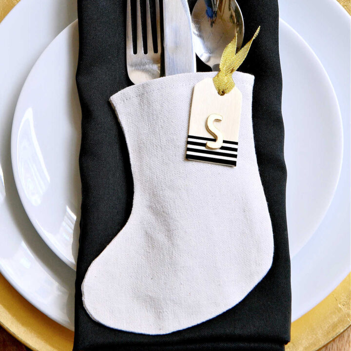 A mini stocking filled with silverware on a plate.
