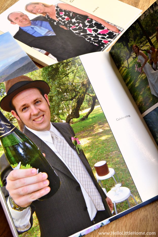 A yearly photo book open to a photo with a man holding a champagne bottle.
