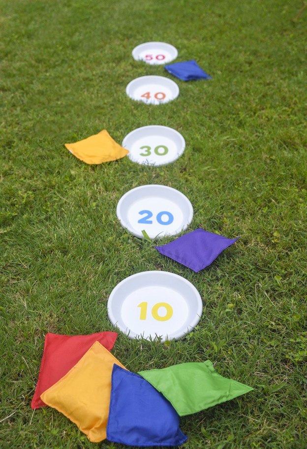 A large Bean Bag Toss Game arranged on the grass.