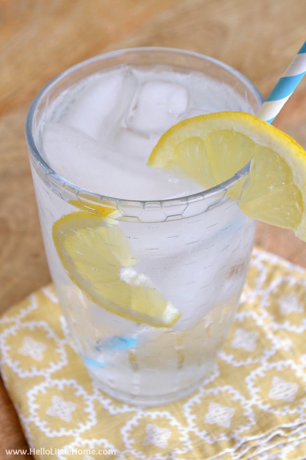 A glass of water with lemon slices in it.