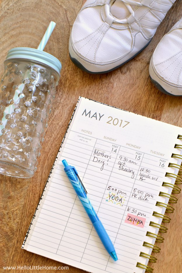 A planner next to a pair of tennis shoes and a water bottle.