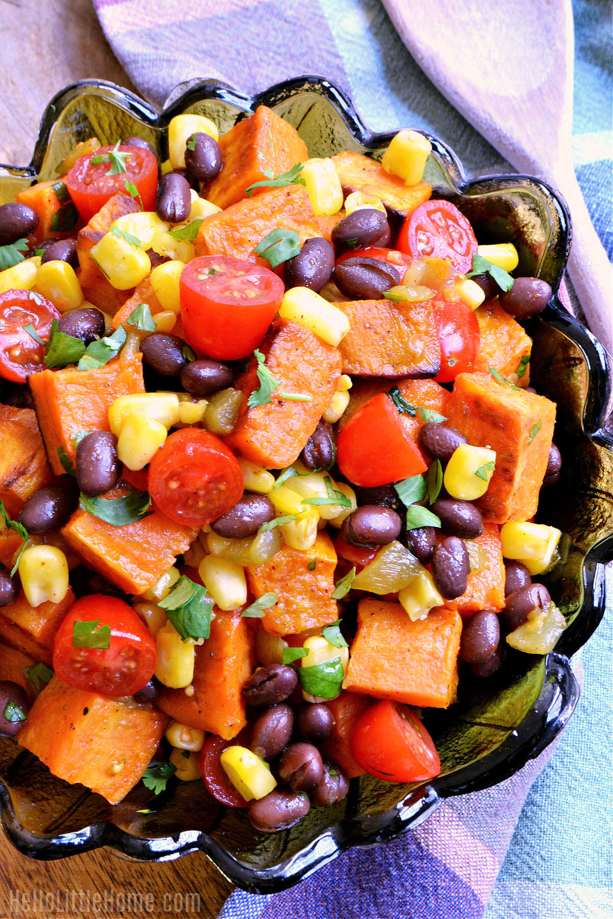 A bowl of the finished sweet potato salad served next to a napkin and spoon.