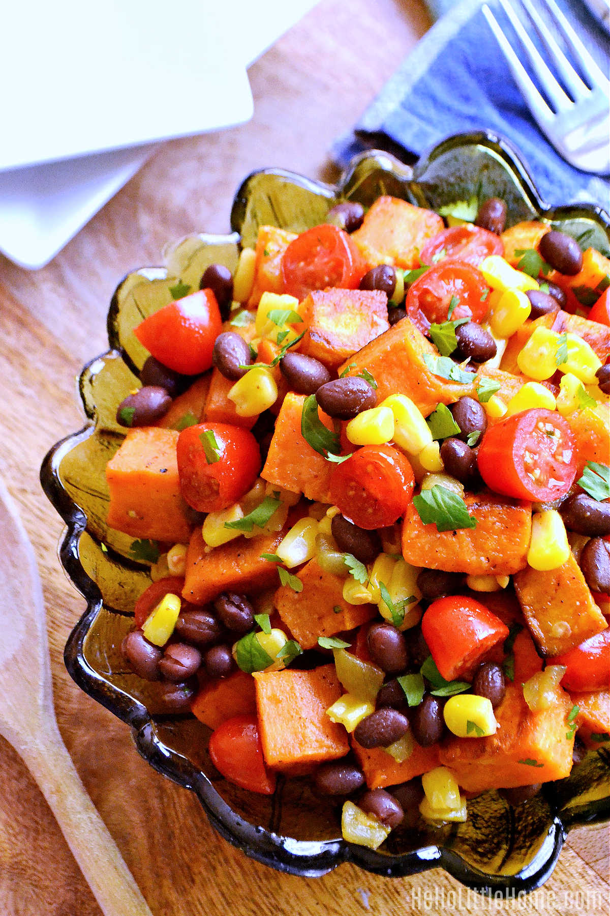 The finished salad served in a glass bowl on a wood table.