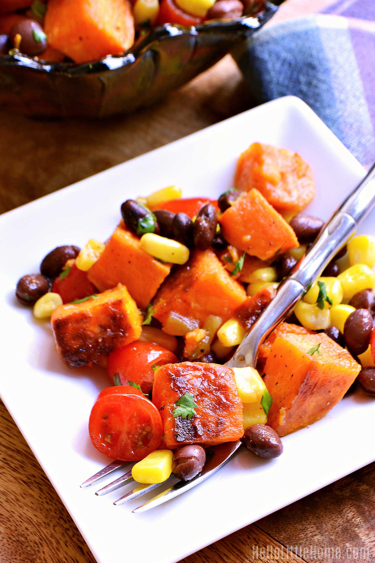 Sweet Potato Salad with Black Beans serve on a white plate with a fork.