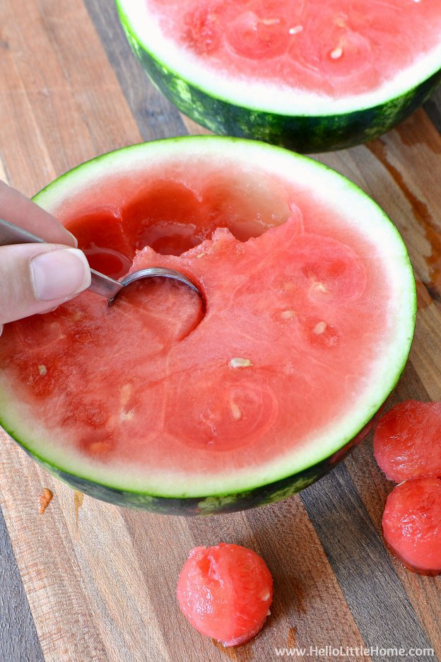 Scooping out melon to make Mini Watermelon Punch Bowls.