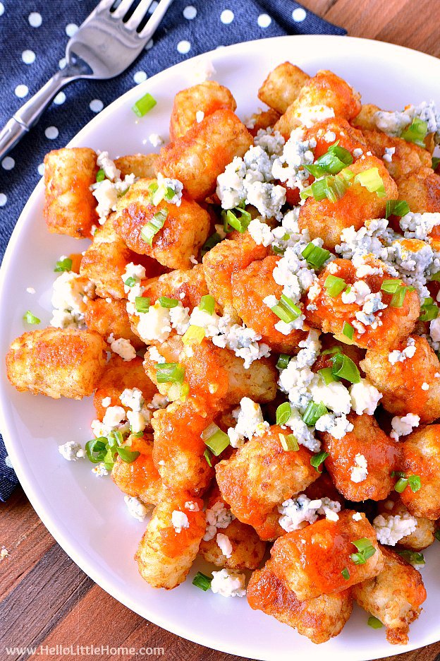 Plate of easy Buffalo Tatchos (Tater Tot Nachos) ... a fun and easy game day recipe! These easy vegetarian tater tot nachos are loaded with a spicy homemade buffalo sauce, creamy blue cheese, and fresh green onions. Makes a great appetizer for game day parties or a yummy snack any day! | Hello Little Home