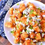 Easy Buffalo Tatchos (Tater Tot Nachos) ... a fun and easy game day recipe! These easy vegetarian tater tot nachos are loaded with a spicy homemade buffalo sauce, creamy blue cheese, and fresh green onions. Makes a great appetizer for game day parties or a yummy snack any day! | Hello Little Home