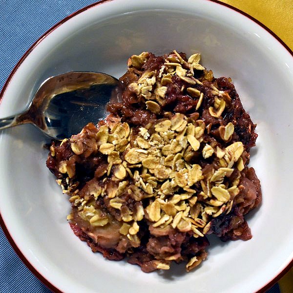 A spoon in a bowl of Slow Cooker Berry Crumble.