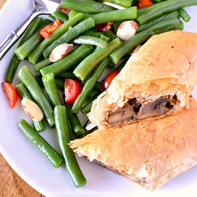 A plate topped with Mushroom Strudel and green beans.