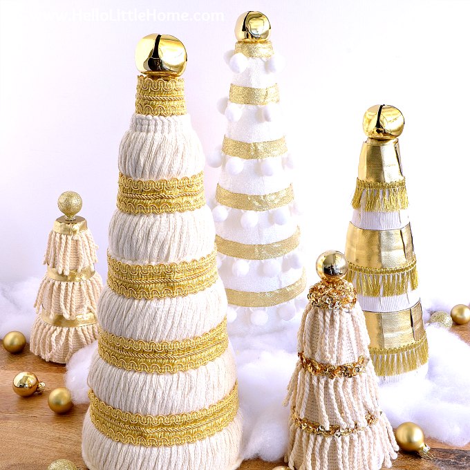 Five Mini Christmas Trees decorated with cream and gold trims and ribbons.