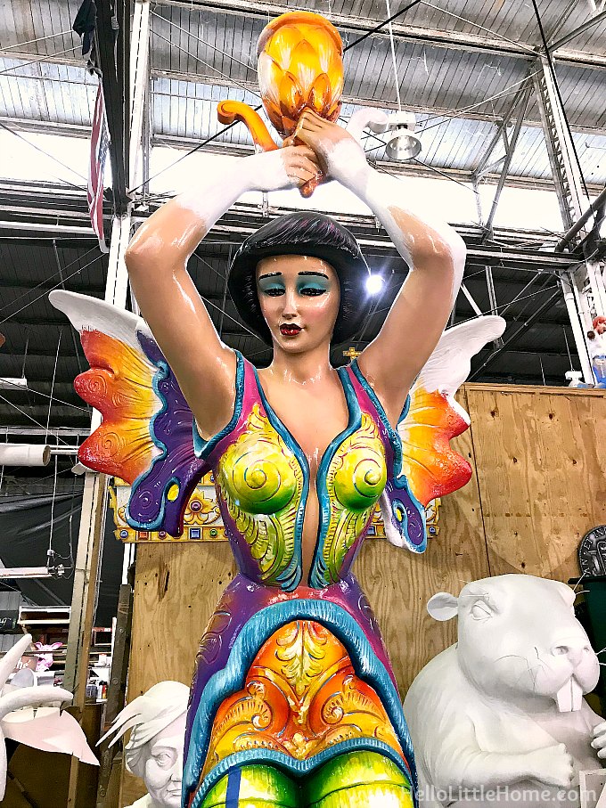 A colorfully painted lady with wings in the warehouse.