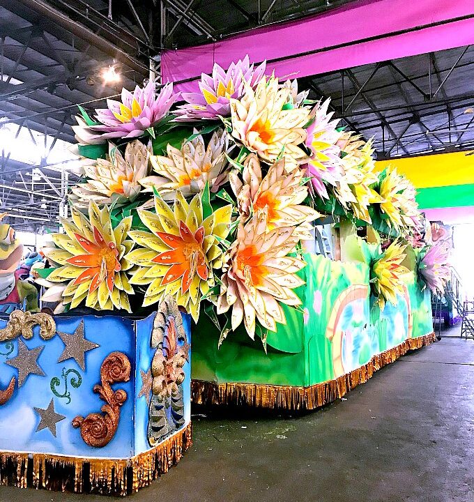 Huge Mardi Gras Float decorated with colorful flowers.