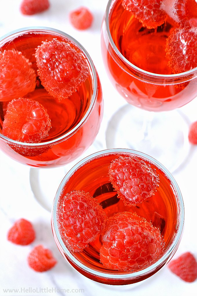Closeup of three of the drinks garnished with fresh raspberries.