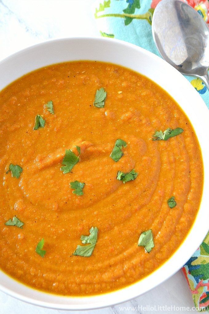 A Bowl of vegan Carrot Soup made with Coconut Milk on a marble table.