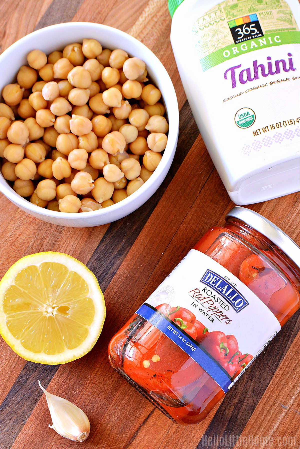 Red Pepper Hummus ingredients arranged together on a wood cutting board.