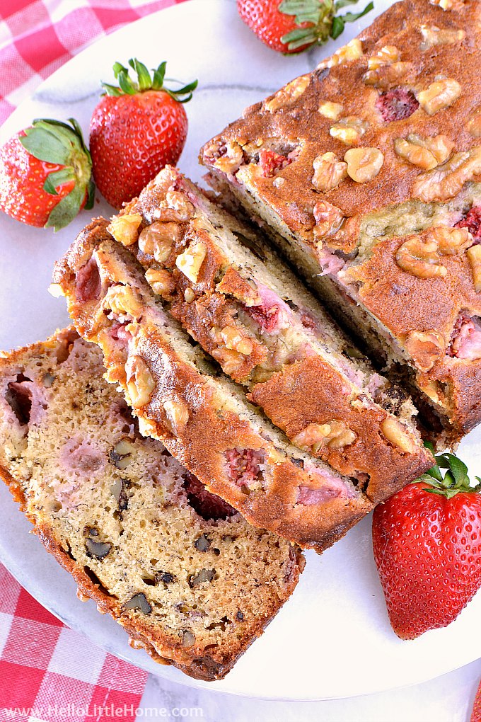 Slices of Strawberry Banana Bread on a marble tray with a checkered pink napkin.