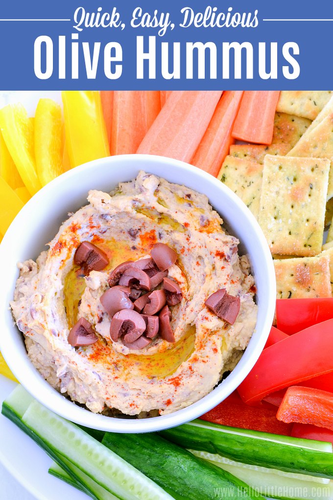 A bowl of Olive Hummus surrounded by fresh veggies.