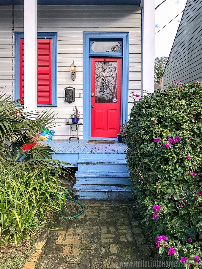 A house with a red door and blue steps in Algiers Point.