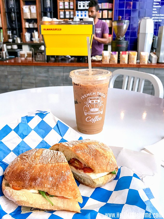 A sandwich and an iced coffee on a white table.