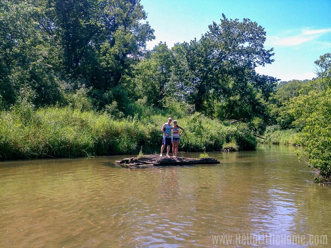 A man and a woman standing on a tiny sandbar in the Kickapoo River.