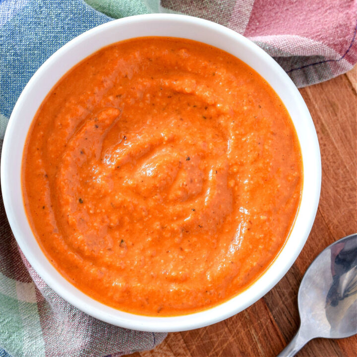 A bowl of Romesco Sauce on a wood table.
