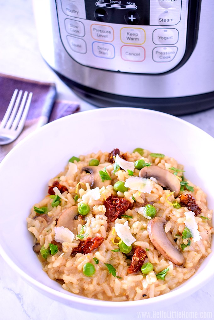 A bowl of vegetable risotto with an Instant Pot in the background.