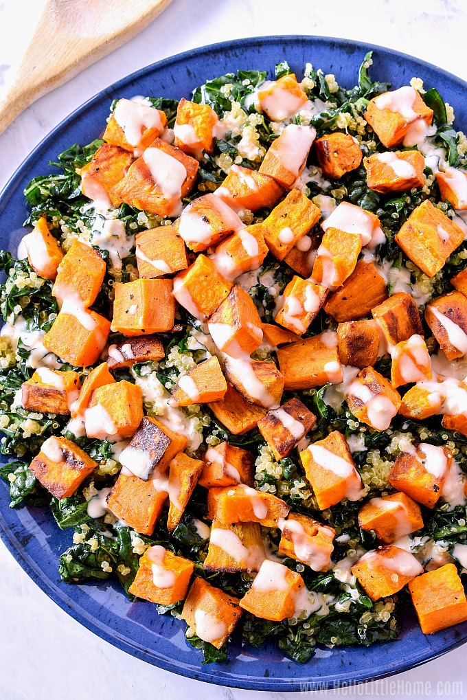 A blue platter topped with sweet potato kale quinoa salad.
