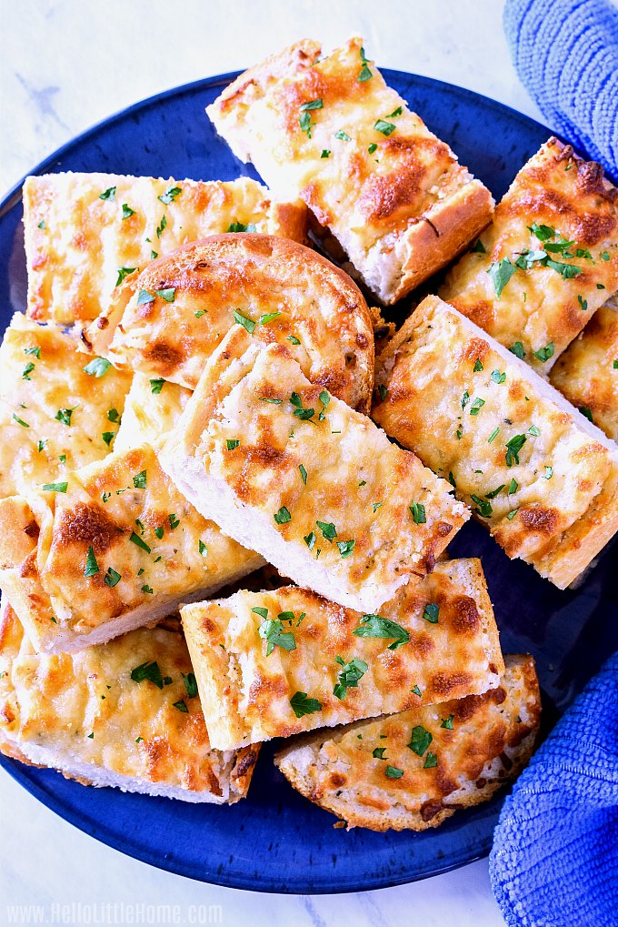 Slices of cheese garlic bread served on a bright blue plate.