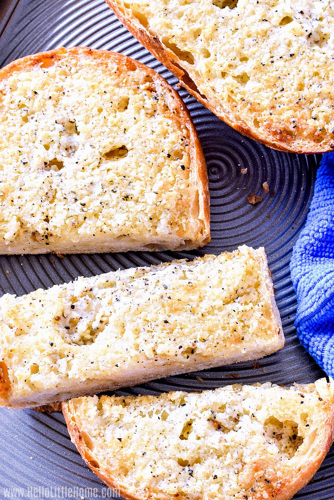 Easy garlic bread recipe shown on a baking sheets with a blue hand towel.