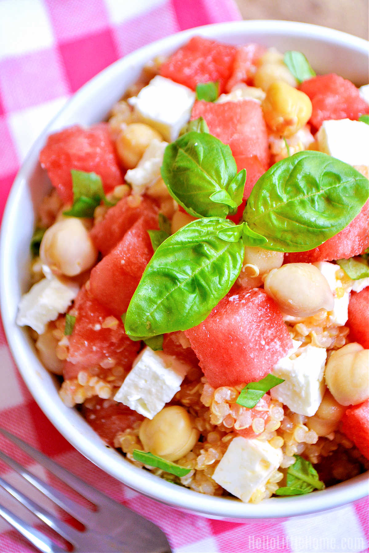 A bowl of Watermelon Quinoa Salad on a checked napkin.