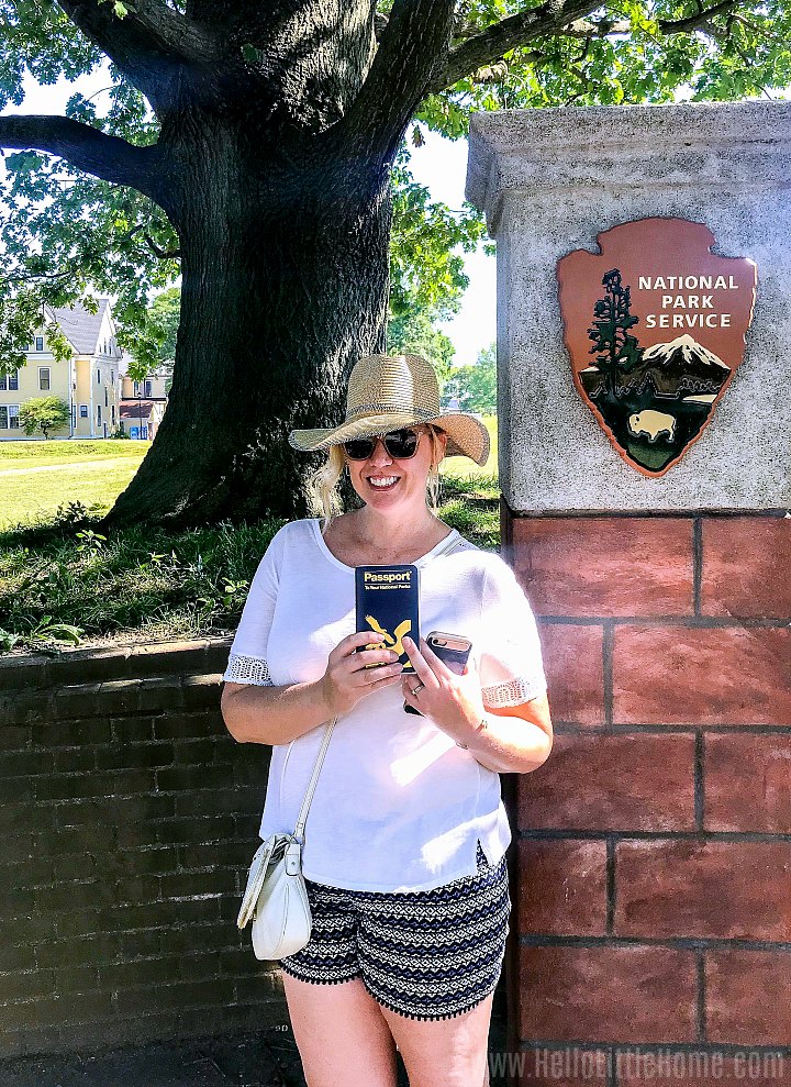 A woman holding a National Parks Passport on the Island.
