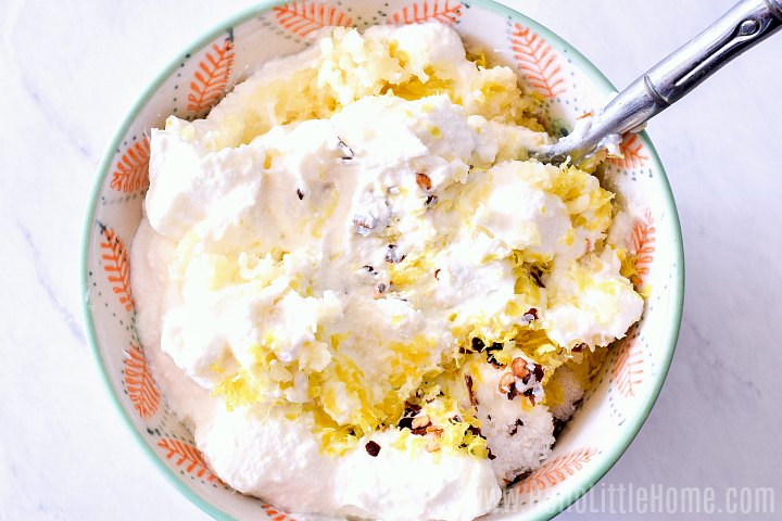 Mixing ricotta, lemon zest, garlic, and crushed peppers together for topping White Pizza.
