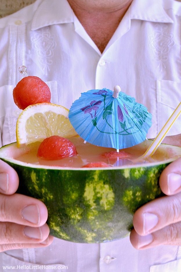 A man holding Watermelon Punch served in a mini watermelon.