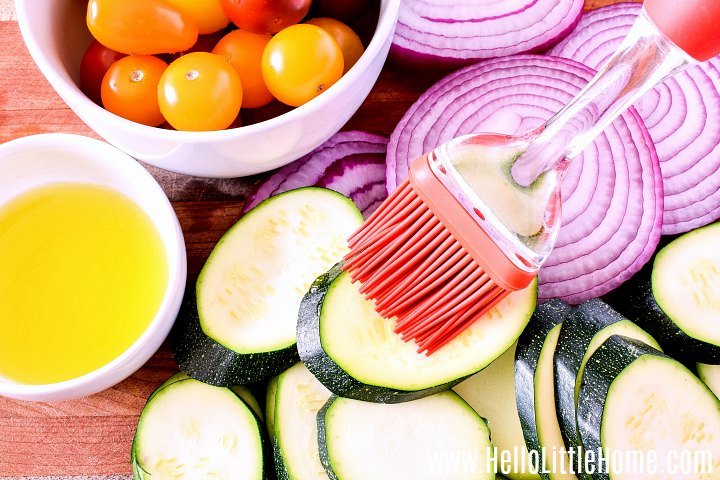 Brushing veggies with olive oil before grilling.