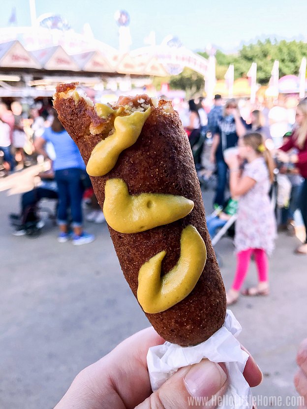 A hand holding a Fletcher's corny dog at the State Fair.