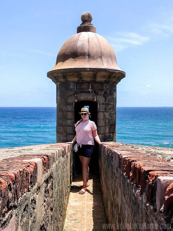A woman standing in a sentry box in Old San Juan.