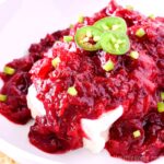Cranberry jalapeno dip appetizer served on a white platter.