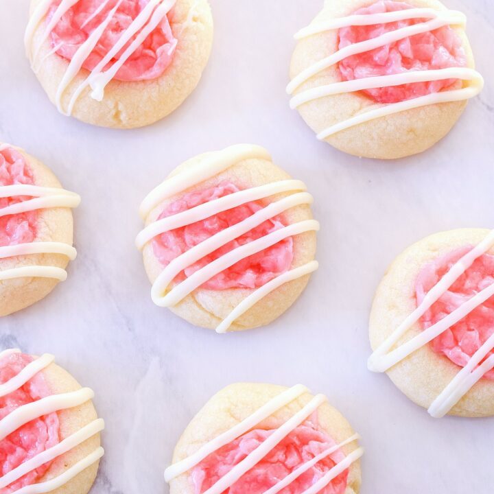Peppermint Thumbprint Cookies arranged on a white marble counter.