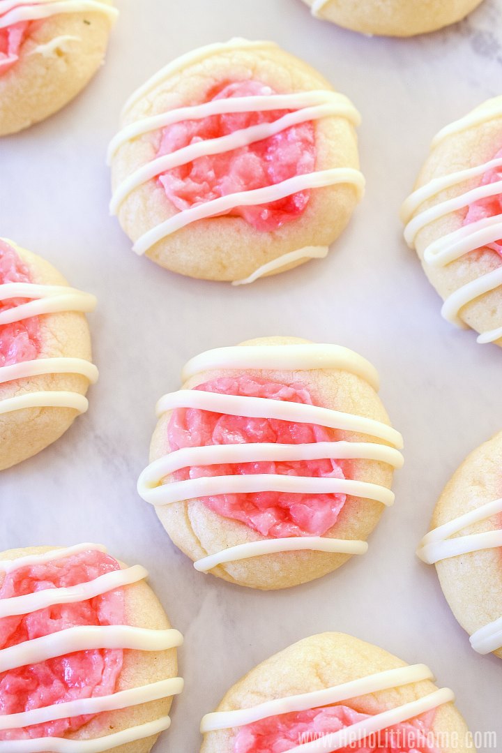 A bunch of Peppermint Thumbprint Cookies on a white marble background.
