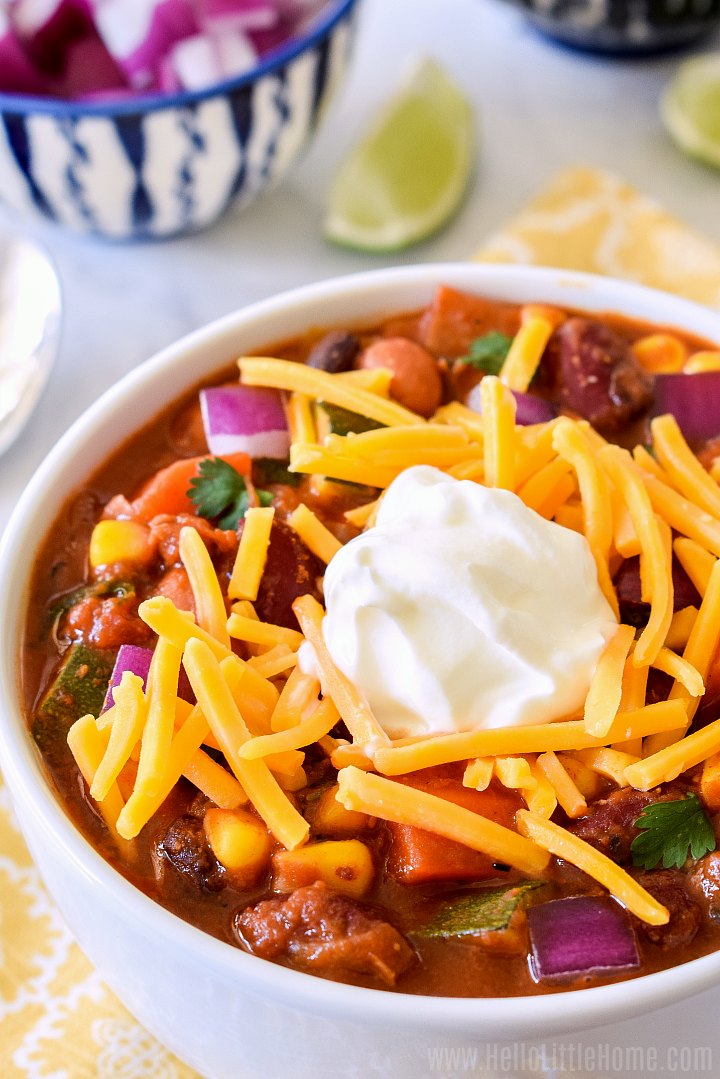 Closeup of a bowl of meatless chili topped with cheese and sour cream.